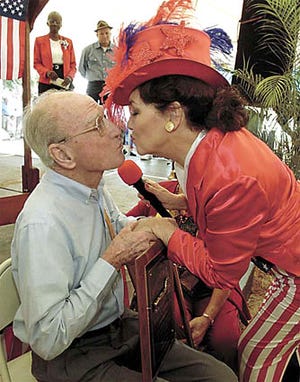 Lake Wales Pioneer of the Year Robert E. Lassiter Jr. receives a congratulatory kiss from Historic Lake Wales Society President Mimi Reid Hardman Saturday during Pioneer Hour. Looking on are Mayor Linda Kimbrough, left, and Danny Baynard, a character actor who portrayed Lassiter's life in agriculture.