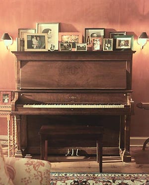 Katie Couric's strives to fill her home with cherished heirlooms. The centerpiece of her music room is her family's piano that she grew up playing and which is covered with special family photographs.