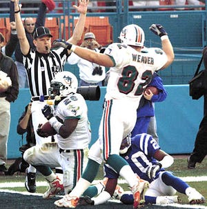 Miami Dolphins running back Lamar Smith, left, scores in overtime giving the Dolphins a 23-17 victory against the Indianapolis Colts at Pro Player Stadium in Miami, Saturday.
