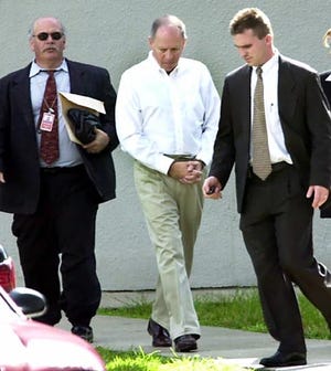 Former Miami City Manager Donald Warshaw, center, is escorted by unidentified FBI agents after he turned himself in to the FBI Thursday.