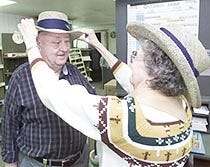 Joan Stranger adjusts the retirement hat on her husband Bert as they get ready to close Dorothy's convenience store in Truro. Their last day will be October 15th.