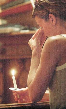 Heather Day of Hampton holds a candle at the altar of the Hampton United Methodist Church as she grieves over the loss of a friend who was aboard American Airlines Flight 11, which crashed into the World Trade Center on Tuesday.