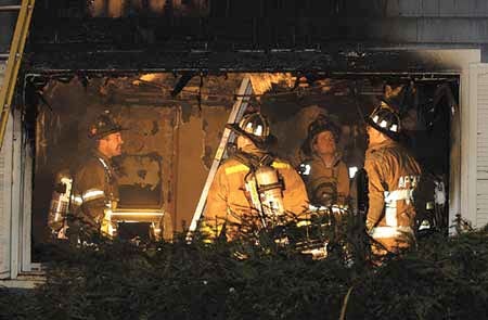 York Beach and York Village firefighters inspect the damage inside a home at 26 Logging Road on Friday night.