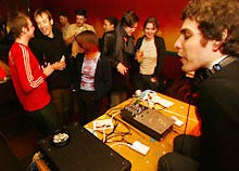 Donnie Darkwave, aka Jonathan Krisel, right, entertains dancers and bar patrons at Balanza in Brooklyn. Darkway said he can work with over 1,000 tunes, using just the two tiny iPODS and the mixer on the table in front of him.