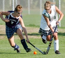 Rachel Silverman of Sandwich (7) impedes the progress of Dennis-Yarmouth's Sara Manoli during yesterday's field hockey game in South Yarmouth won by the Dolphins 3-2. Silverman had one of the goals for Sandwich, which nearly completed a comeback from a 3-0 deficit.