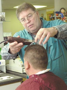 Barber Les Searles works on a customer in his Hampton shop.