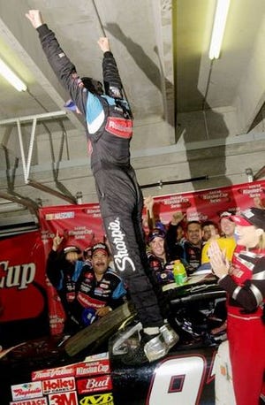 RIC FELD/The Associated Press
Kurt Busch leaps on his car as he celebrates in the garage area after winning the NAPA 500 Sunday.
