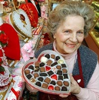 Jane Gauthier, a nine-year employee at Ghelfi's Candies, tempts Valentine's Day customers at Mashpee Commons with a heart-shaped box of hand-dipped chocolates.