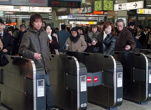 Tokyo commuters go through ticket gates by flicking their Suica cards that work as tickets in Shinjuku JR Station in Tokyo. Gadget-loving Japan is once again embracing tha new technology that has yet to catch on in the United States and many other parts of the world -- the plastic embedded with a tiny computer chip that permits transctions without the hassle of cash.