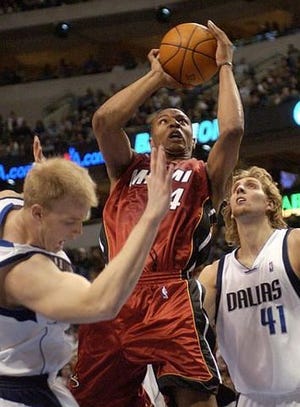 Miami's Caron Butler, center, goes up for a shot attempt as he splits Dallas' Evan Eschmeyer, left, and Dirk Nowitzki Saturday.