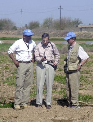 U.N. weapons inspectors stop at a roadside to make a satellite phone call on their way to Tikrit, Iraq on Monday. Satellite phone usage may increase in Iraq if landline and mobile phone networks are damaged.