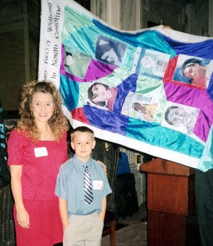 Davis-Townsend Elementary fifth-grader Taylor Ward (right) stands with his teacher, Melinda Hedrick, in front of the flag that features his artwork at a ceremony in Washington, D.C., last week.