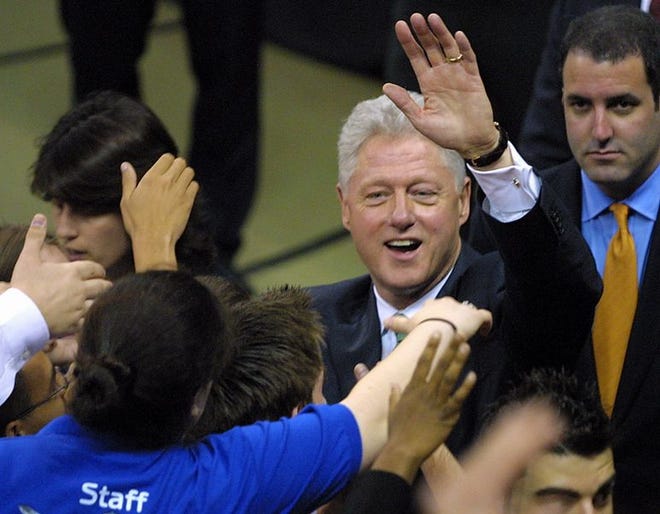 Former president Bill Clinton waves to the crowd before exiting the O'Connell Center Thursday