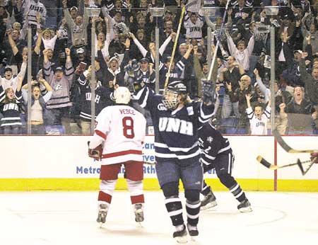 The University of New Hampshire's Robbie Barker raises his stick as Wildcat fans in the stnads join the celebration following UNH's first goal in a 3-2 NCAA semifinal win over Cornell on Thursday in Buffalo, N.Y.