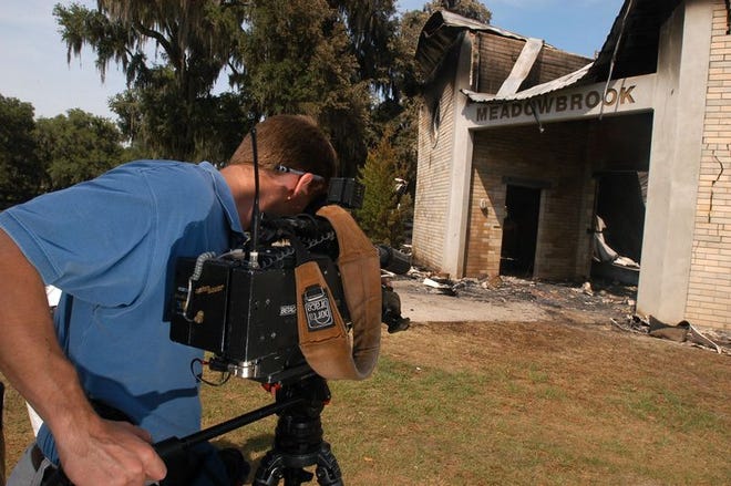 A television photojournalist films the ruins of the stallion barn at Meadowbrook farm in Irvine on Wednesday.