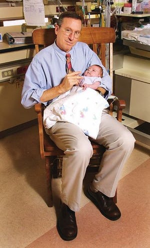 Dr. David Burchfield holds patient Megan Giles at Shands at UF.