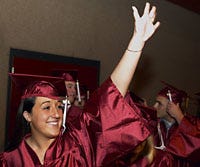 Courtney Ayers tries to catch someone's attention before the Falmouth High School graduation begins in the field house yesterday. The class's theme song for the night was "Forever Young."