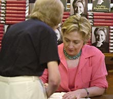 Sen. Hillary Rodham Clinton signs a copy of her book, "Living History," for fellow Wellesley College alum Bonnie Meras yesterday at the Bunch of Grapes bookstore in Vineyard Haven.