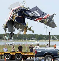 The tail section of a Colgan Air Beechcraft 1900 is lifted onto a flatbed trailer yesterday after it was recovered from Nantucket Sound, off Great Island. The wreckage will be examined by federal investigators.