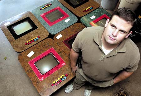 Raymond police officer Kevin Fitzgerald stands next to video poker games that were confiscated in what police called a gambling ring at a local store.