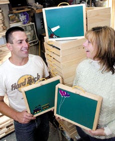 Brain and Shelley Mahlert display children's activities boxes that they sell at their business in Newfields.