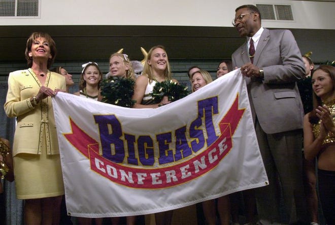 USF President Judy Genshaft, left, and Athletic Director Lee Roy Selmon, right, hold the Big East banner after accepting a bid to join the conference on Tuesday.