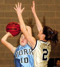 York High School's Maura Roche (left) is fouled by Traip Academy's Kelly Finneran during Tuesday's girls basketball game in Kittery