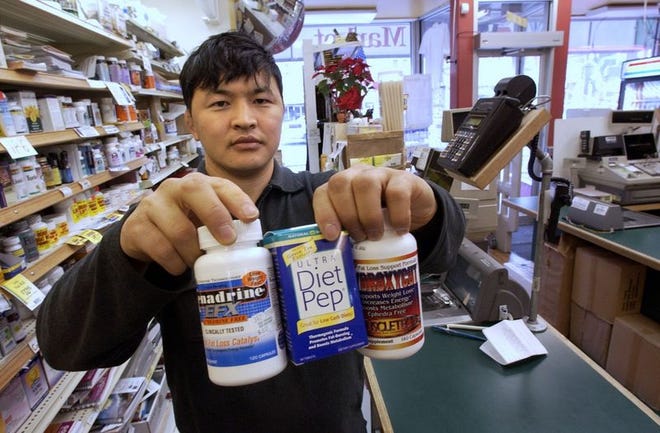 Store manager Ganba Puntsg holds ephedrine-free dietary supplements at the Yes Natural Food store in Washington Monday. People who thought ephedra helped them drop pounds now are looking to guarana, bitter orange and green tea extract.