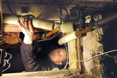 Steve Boule, an apprentice plumber with Heritage Plumbing, Heating & Cooling, works in a crawl space at a Portsmouth home on Tuesday to fix a section of damaged copper pipe that had been frozen in the cold weather. During last weekend's cold spell, Boule worked 18 hours on Saturday alone.