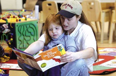 Tina Boyd-Ayotte reads to er daughter, Shaylen, 3, at the Community Campus on Thursday morning. The book, "The Snowy Day," and others are offered free to participants. There are many programs offered during this time frame to low income families for children under 5.