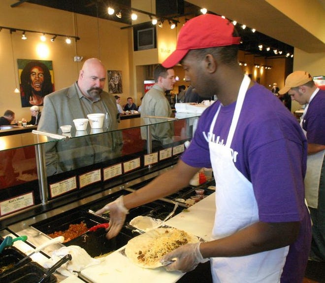 Clarence Palmer makes a burrito at Moe's

Southwest

Grill, where

customers watch their food being made and pick what they want on it.