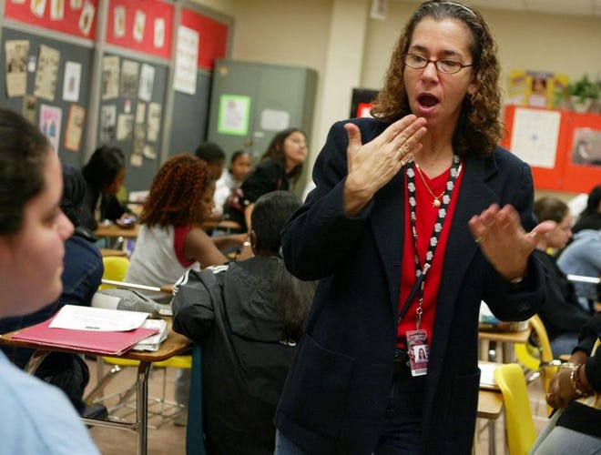 Cathy Oshrain shows a sign to one of her American sign language students at North Miami Beach High School in Florida.