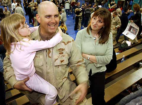 Sgt. 1st Class Sam Leneave III of Gainesville is reunited with his family on Saturday at Fort Stewart, Ga., after returning from Iraq. Leneave served in the same unit as Cpl. John Travis Rivero and Spc. Jeffrey Mattison Wershow, two former Gainesville residents killed last year in Iraq.