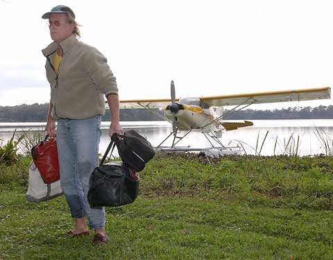 Tom Goodwin collects his luggage from the edge of Bivens Arm after an emergency landing on Monday.