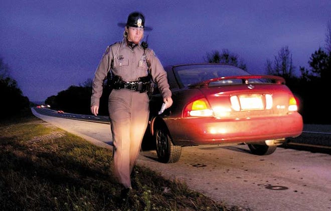 Florida Highway Patrol trooper Sheila Walker returns to her unmarked patrol car after pulling a man over for speeding just south of Paynes Prairie Preserve State Park on Thursday.