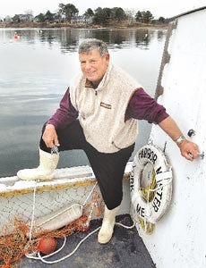 John Bridgesm the new harbor master, stands on his boat at the York town dock on Thursday morning.