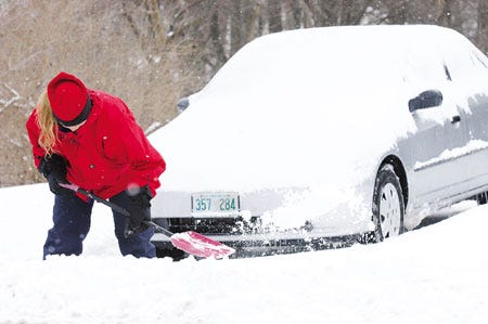 Kit Miller digs her car from a driveway along High Street in Hampton Beach. "Oh, the joys of living in New England," she said as she used a child-sized shovel for the task.
