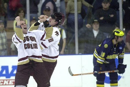 Boston College's Justin Dziama (left) and Brian Boyle celebrate the Eagles' overtime victory in the NCAA Northeast Regional final on Sunday in front of a stunned David Moss of Michigan.