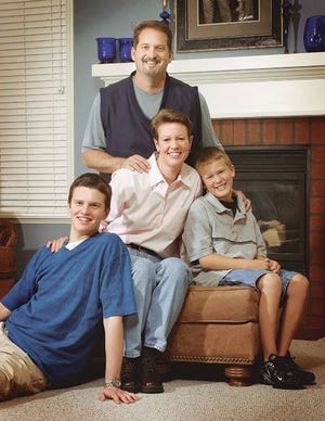 University of Florida volleyball coach Mary Wise surrounded by her family: clockwise from left, son, Matt, husband, Mark, and son, Mitchell, in the family room of their Haile Plantation home.