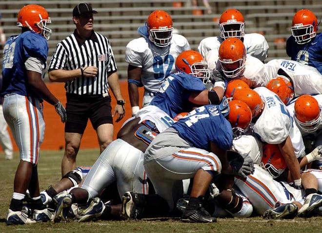 Members of the orange and blue teams pileup Saturday morning during the Gator's scrimmage at Ben Hill Griffin Stadium.