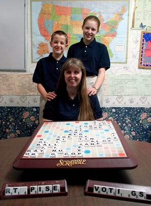 Elizabeth Cook, above, is shown with Daniel, 10, and Anne, 13, with a Scrabble game at their home. The youngsters are competing Saturday with 99 other teams in the National Scrabble School Program Championship in Boston. Cook, top, looks at her daughther's rack while Daniel calculates his score during a practice game. Scrabble is used in the schools to teach vocabulary, spelling, math, creativity and a host of other skills.