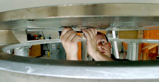 Doug Lyons, senior superconducting magnet engineer for Bruker Biospin Corporation, adjusts a plate at the bottom of a magnet in preparation to remove the magnet from University of Florida's Brain Institute on Thursday.
