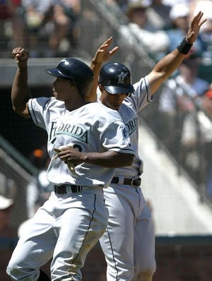 Florida's Juan Pierre, left, and Damion Easley celebrate after scoring in the fourth inning on Luis Castillo's double in San Francisco during Sunday's 9-8 loss to the Giants.