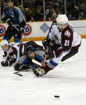 Colorado Avalanche's Peter Forsberg (21) skates away from San Jose Sharks' Jason Marshall, facing camera on ice, in the first period of Game 5 of an NHL Western Conference semifinal series in San Jose, Calif., Saturday, May 1, 2004. At left are San Jose's Mike Rathje, top, and Colorado's Marek Svatos (40). The Avalanche won 2-1 in overtime. The Sharks lead the best-of-seven series 3-2.