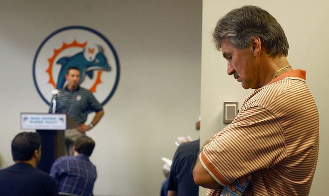Dolphins coach Dave Wannstedt, right, stands in the back of the room at the Dolphins training camp center in Davie listening to remarks by new offensive coordinator Chris Foerster on Monday.