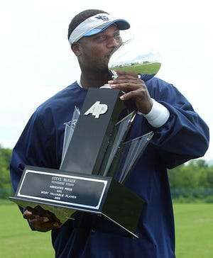 Tennessee Titans quarterback Steve McNair said "I feel like Tiger Woods" as he kisses the Associated Press NFL Most Valuable Player trophy presented to him by Associated Press Tennessee Chief of Bureau Ken Flanagan following a morning workout at the Titans' training facility in Nashville, Tenn.,Tuesday.