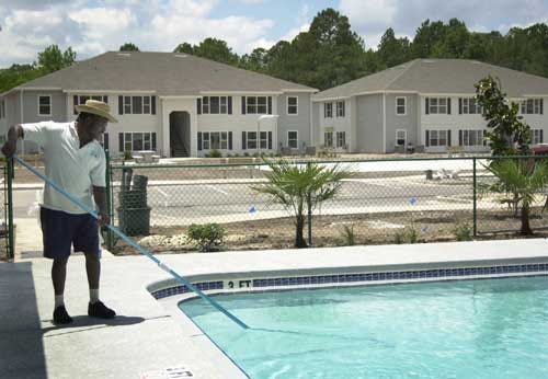 Johnny Dixon of Pools by Ripley cleans the clubhouse pool in the new Eden Park apartment complex on Friday. The first 16 apartments at Eden Park at Ironwood, a 104-unit complex at 1330 NE 39th Ave., have opened.