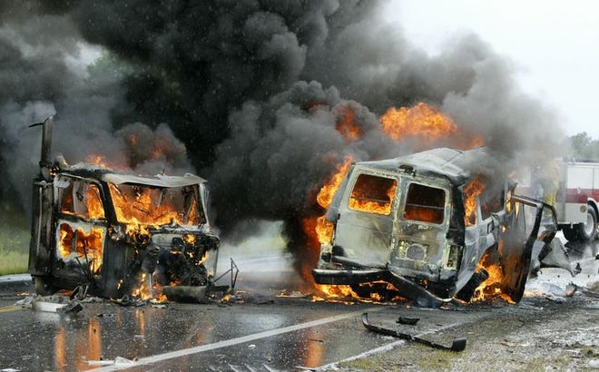 Flames engulf a van, right, containing five passengers following a head-on collision Friday with a tractor-trailer on State Road 60. Five people died in the crash.
