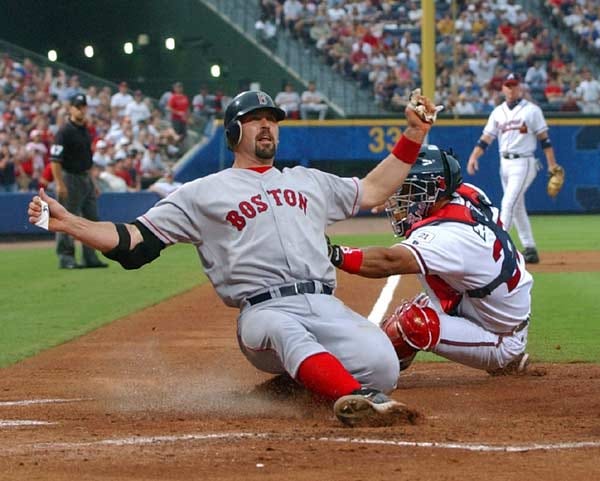 Boston's Jason Varitek slides home safe from second on a Bill Mueller single as Atlanta catcher Johnny Estrada tries to make the tag in the second inning at Turner Field. The game was not complete at press time.