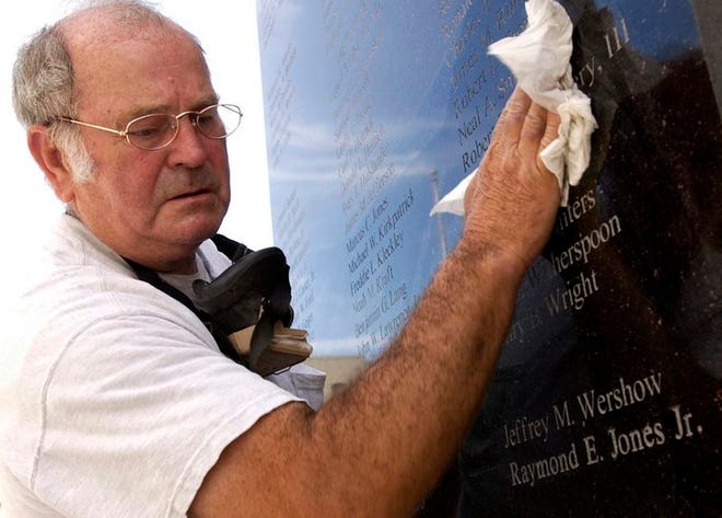 O.T. Davis cleans off the plaque Friday morning after sandblasting the name of Army Sgt. Raymond E. Jones Jr. into the memorial outside the Alachua County Criminal Justice Center.